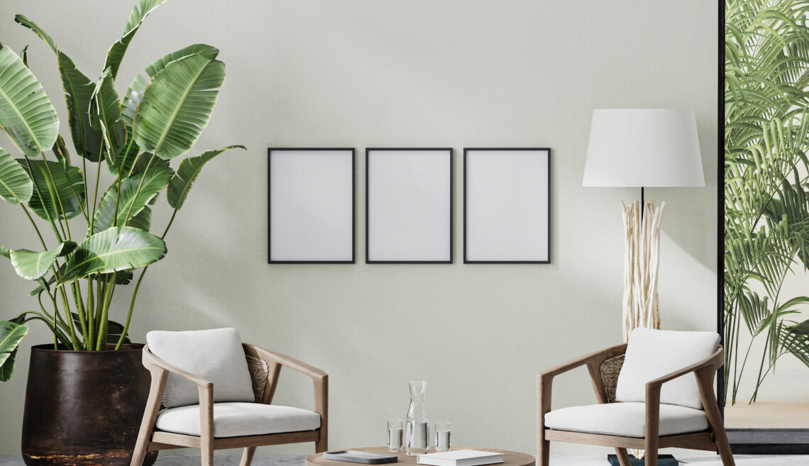 poster frames in room interior with light neutral wall with sunlight and wooden furniture with tropical plant and palm leaves, 3d rendering